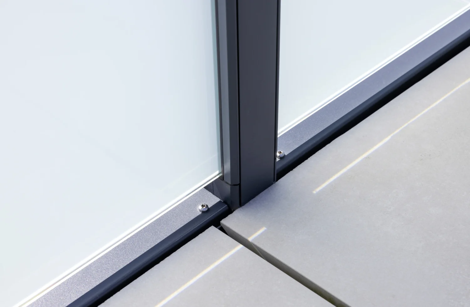 Detailansicht einer modernen Glaswandbefestigung auf einer Betonoberfläche